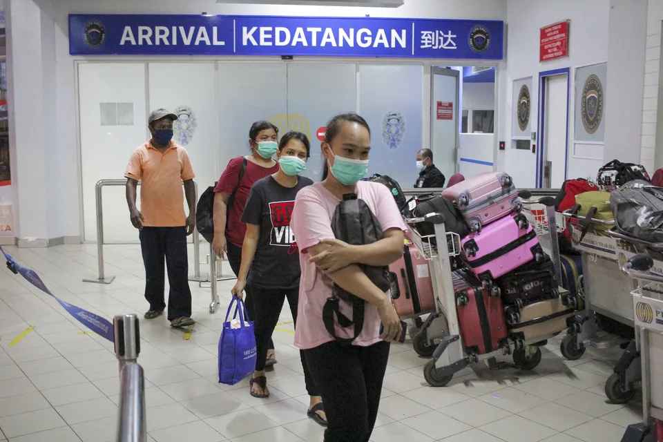 Indonesian migrant workers walk pass an immigration check point at the Batam International Port on January 3, 2022. The government tightens surveillance on international arrivals to curb the spread of the Omicron coronavirus variant. (Antara Photo/Teguh Prihatna)